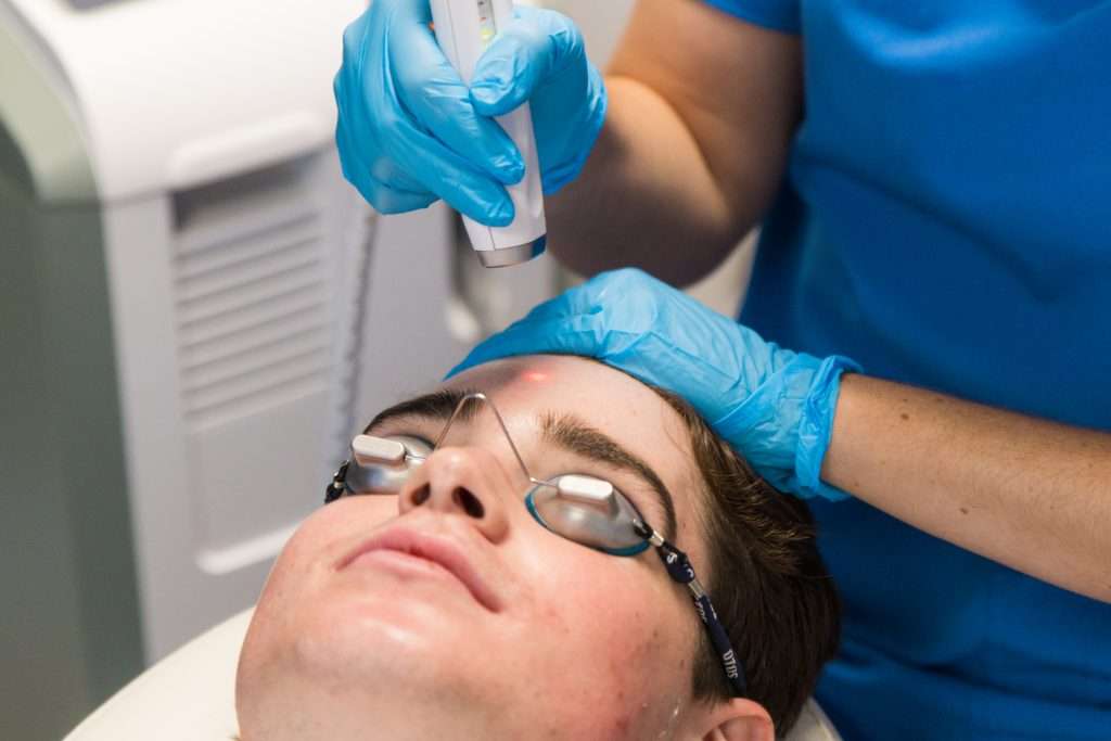 Boy having laser treatment for acne